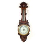 A carved Oak aneroid barometer