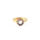 An 18ct Gold ring set with central Opal surrounded by light blue stones,