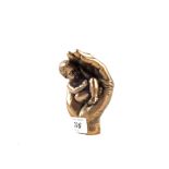 A bronzed figure of a baby in hands,