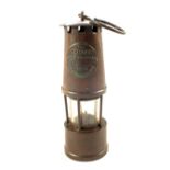 A Brass miners lamp by The Protector Lamp & Lighting Co
