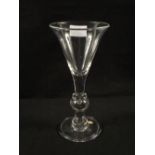 A Georgian heavy baluster wine glass with trumpet bowl,