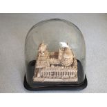 A Balsa wood temple carving under glass dome,