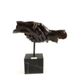 A Bronze of clasping hands on black variegated marble stand,