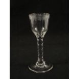 A Georgian wine glass with leaf engraved ogee bowl on faceted stem and plain foot,