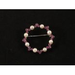 An 18ct White Gold circular brooch set with Cultured Pearls and Pink Sapphires