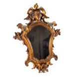 A matched pair of late Georgian/Regency carved and gilded mirrors with decoration and female head