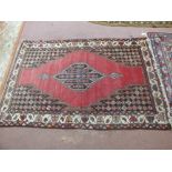 A Persian red ground rug with central medallion,