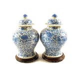 A pair of 19th Century Chinese blue and white globular jars and cover with floral decoration,