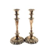 A pair of 19th Century Sheffield plated candlesticks with embossed foliate decoration,