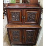 An Edwardian Mahogany two tier cupboard with carved panels