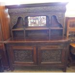 A 19th Century mirror back sideboard profusely carved with birds, fruit foliage,