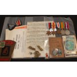 A WWII mounted medal group of five with ephemera, captured German photos and insignia to Miller,