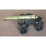 A Brass cannon on a cast iron wheeled carriage