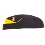 A Royal Norfolk Regiment field service side cap with yellow trim and badge