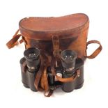 A pair of military binoculars with leather case