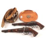 A quantity of military badges and buttons (on belts) with a Copper tray and two replica pistols