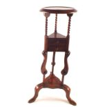 An Edwardian Mahogany jardiniere stand with barleytwist supports and two drawers