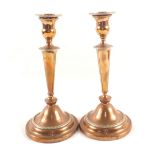 A pair of Victorian Adam style Copper originally Silver plated candlesticks with domed circular