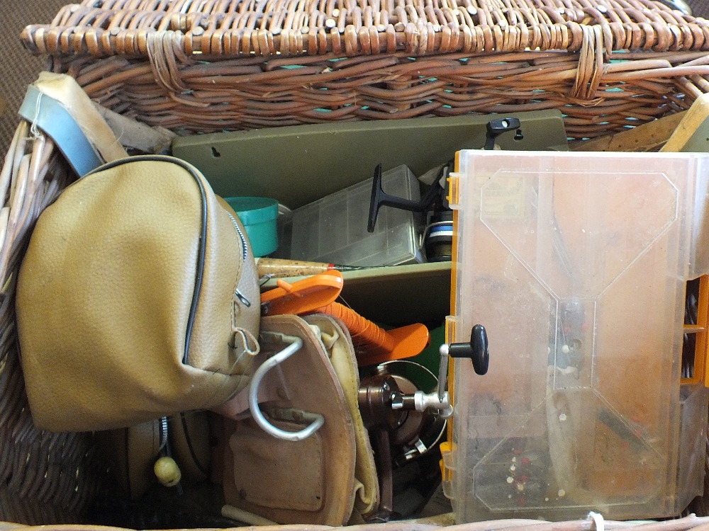 A fishing basket containing various tackle including Penn Squidder,