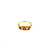 An 18ct Gold three stone Ruby set ring intersected by four Diamonds,