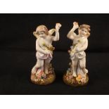 A pair of German porcelain figurines of winged cherubs,