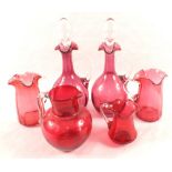 A pair of Cranberry claret jugs and four various jugs