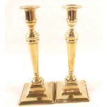 A pair of late 18th Century Adam style Brass candlesticks on beaded square bases,