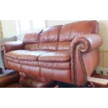 A modern tan leather four piece suite, comprising a three seater sofa,