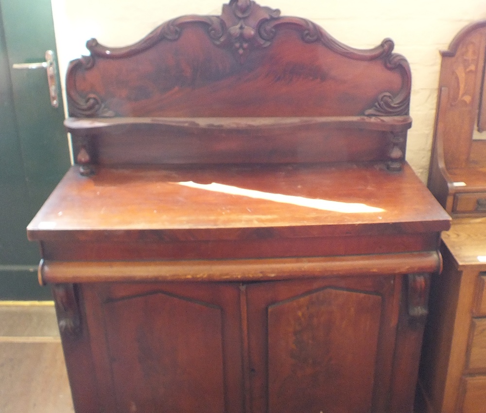 A Victorian carved Mahogany two door chiffoniere