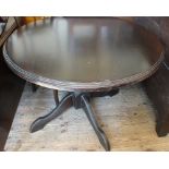 A circular Mahogany dining table on turned column and quadrical supports