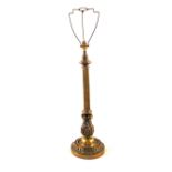 A large early 20th Century Brass table lamp with fluted and ornately cast decoration on wide