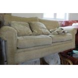 A modern cream upholstered three seater settee