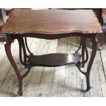 An Edwardian Mahogany shaped top two tier table