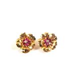 A pair of large Gold flower shaped clip earrings set with Rubies and a small Diamond set as the