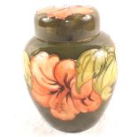 A Moorcroft Hibiscus pattern ginger jar on green ground with stickers and marks to base (inside lid