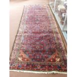 A Persian blue ground floral runner,
