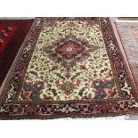 A Persian cream and red rug with central medallion