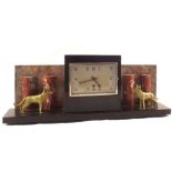 An Art Deco rouge and black marble clock flanked by two spelter dogs