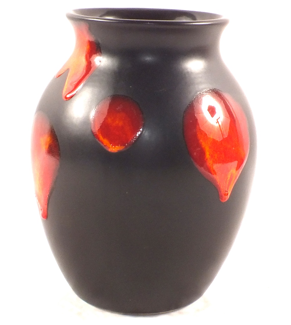 A Poole black ground vase with red and orange roundels