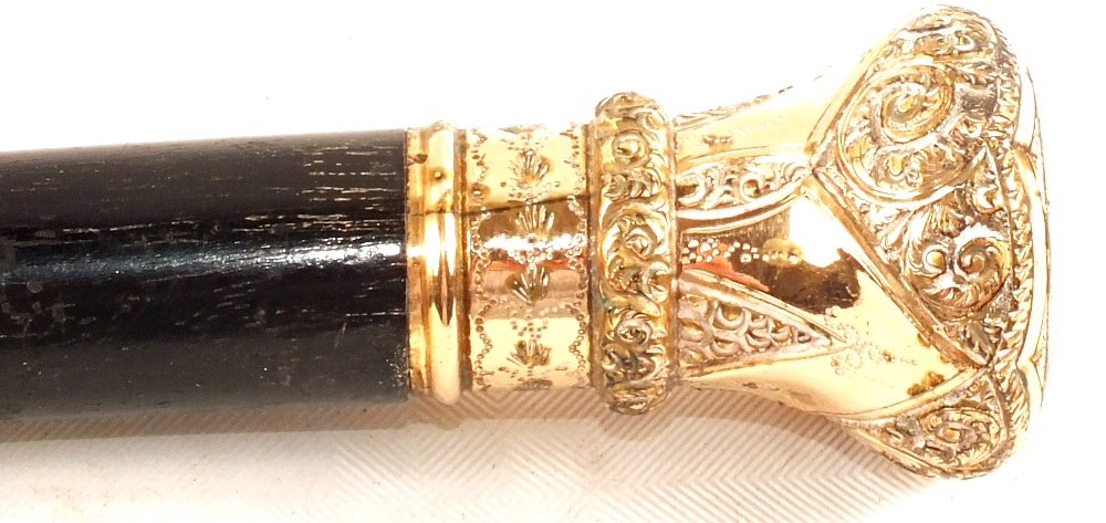 A gents walking cane with decorative metal grip