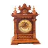 An Ansonia mantel clock in a carved Pine case