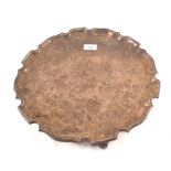 A large Silver salver with pie crust edge on four feet, by Garrads,