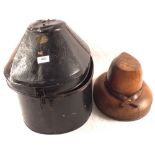A tin hat box containing a vintage wooden hat mould