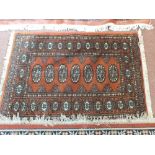 A Pakistan brown ground wool rug, 70" x 48" and one other,