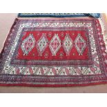 A Persian red ground rug with geometric designs,
