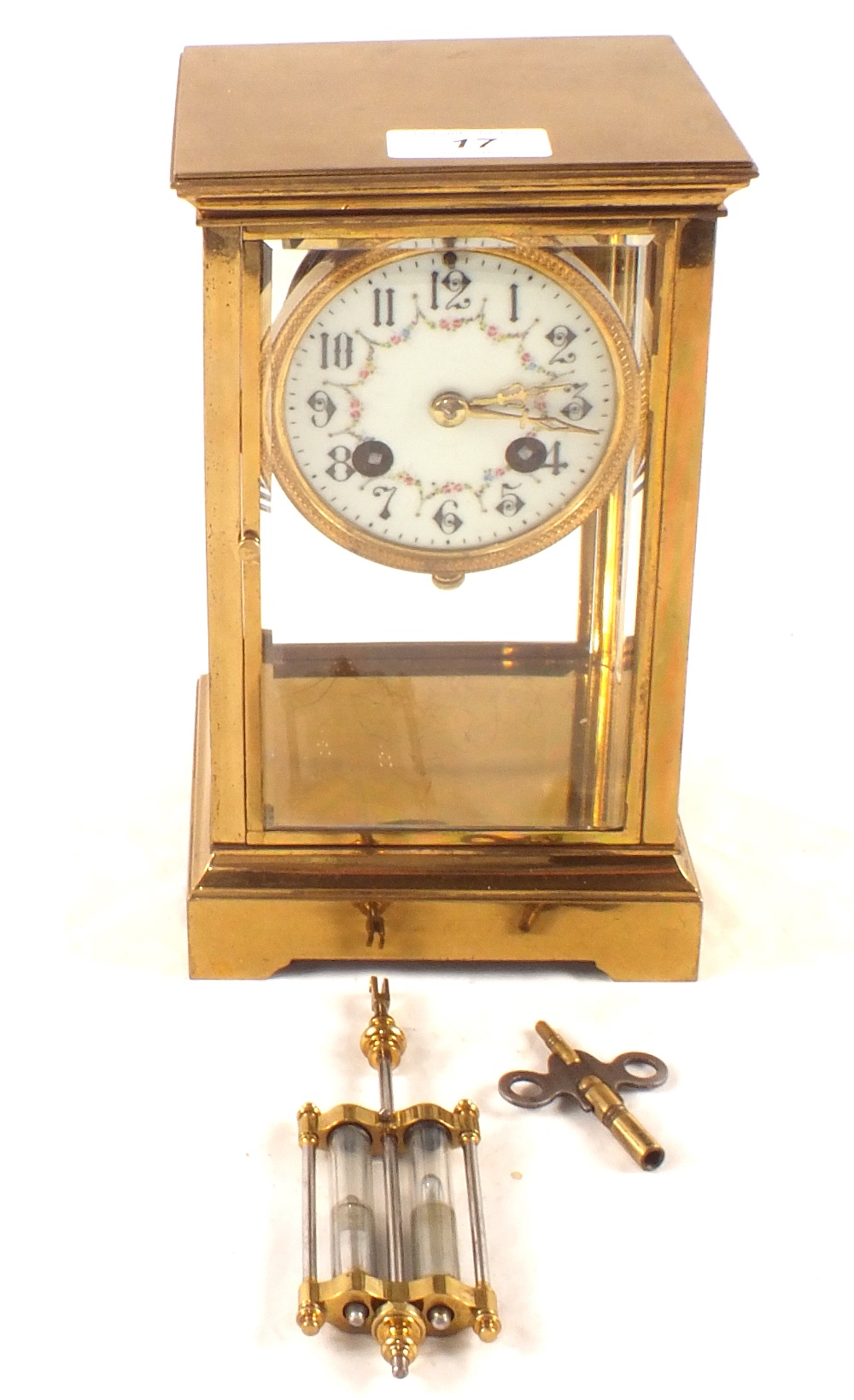 A Brass four glass mantel clock with painted enamel dial and mercury pendulum