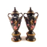 A pair of Edwardian black ground bird and floral vases and covers