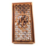 A Chinese softwood panel with deep figure and floral carving,
