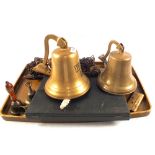 A lacquered tray containing two Brass ships bells,