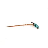 A yellow metal stick pin with perching bird top body set with Turquoise stones and red stone set